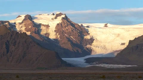 Static view of sunlight hitting the Skaftafell's glacier and rugged mountain Stock Footage 345126736