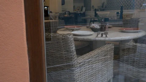 Static view through a glass window of a restaurant waiter dressing tables. Stock Footage 122431474