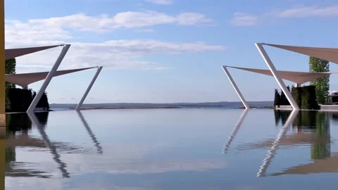 Static water-level view of resort pool with canopies and open horizon Stock Footage 282532337