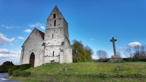 Static wide shot of an ancient stone church and a monumental stone cross on a gr Vidéo 332803824