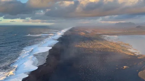 Static wide shot of endless black sand coastline and ocean waves at sunset,.. Stock Footage 327683761
