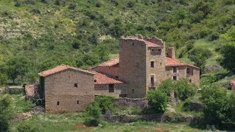 A static wide shot of a historic stone building with a tower and red-tiled roofs Stock Footage 346706925