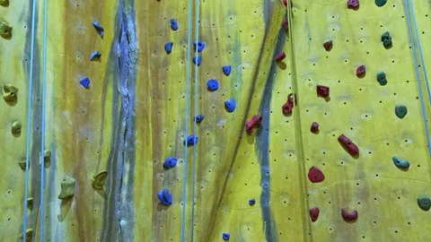 Static Wide Shot of Indoor Rock Climbing Wall with Colorful Holds and Ropes Video stock 313873345