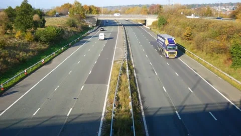 A static, wide shot of light traffic flowing on a motorway in the UK Stock Footage 143014027