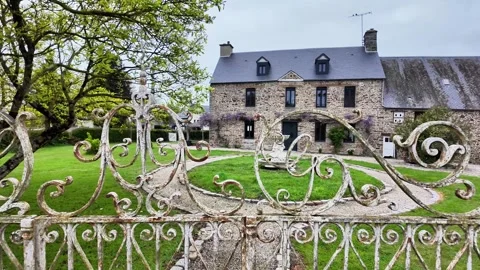Static wide shot of a luxury stone country house seen through an ornate weathere Vídeos de archivo 332679482