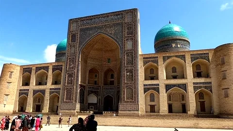 Static wide shot of Mir-i Arab Madrassah with tourists in Bukhara Stock-Footage 335539741
