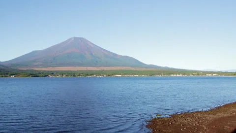 Static wide shot of Mount Fuji above Lake Yamanaka under clear morning sky Stock Footage 321120739