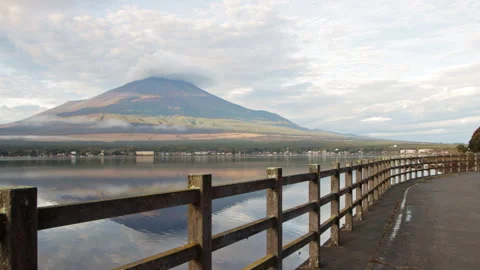 Static wide shot of Mount Fuji reflected on Lake Yamanaka with curved walkway Stock Footage 321124847