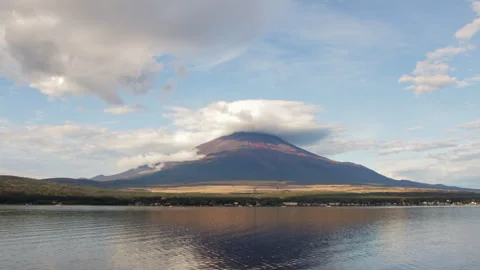 Static wide shot of Mount Fuji with lenticular clouds reflected in Lake Yamanaka Stock Footage 321128208