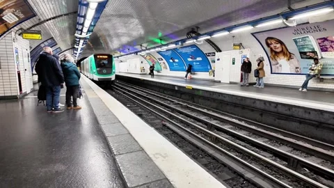 Static wide shot of a Paris Métro station platform as a train arrives Vídeos de archivo 332666769