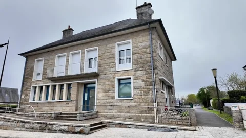 Static wide shot of a traditional stone building on a quiet French village corne Vídeos de archivo 332679646