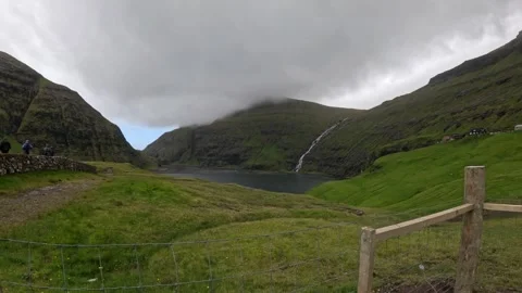 Static wide view of Saksun lagoon and mountains with tourists, Faroe Islands Stock Footage 339364640