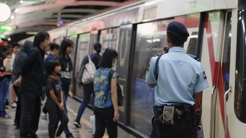 Station attendant looking at crowd rushing into metro train Video stock 115960904
