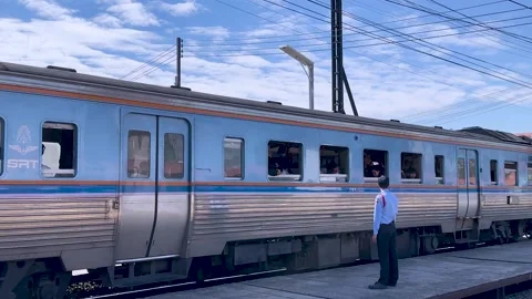 Station Guard Watching Local Passenger Train Depart in Thailand Stock Footage 323891929