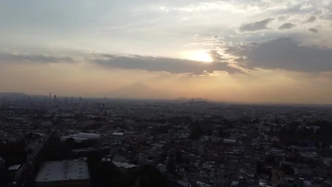 Stationary drone hover over Puebla Mexico at sunset with volcano and golden sky Stock Footage 307833094