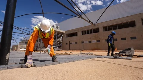 Stationary time lapse of bricklayer workers laying out pavement in parking 動画素材 121778850