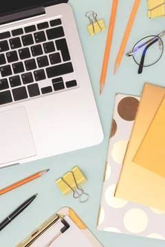 Stationery and laptop on a blue background. Stock Photos