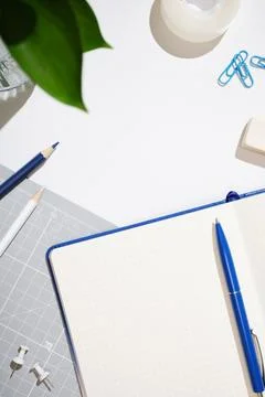 Stationery background with empty notebook page, pen, pencils, eraser, tape, n Stock Photos
