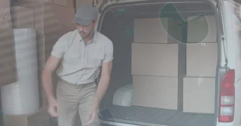 Statistical data processing against caucasian delivery man stacking boxes in his 库存照片