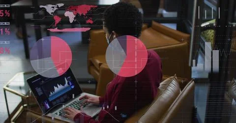 Statistical data processing against man wearing face mask using laptop at office Stock Photos