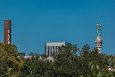 Statue and smoke stack on river 스톡 사진