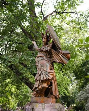 Statue of angel with shield in park surrounded by trees Paris France 25 May 2025 Stock Photos