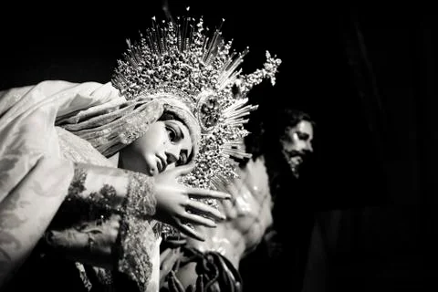 Statue of a begging virgin, crying, open arms, statue of Christ in the backgroun Stock Photos