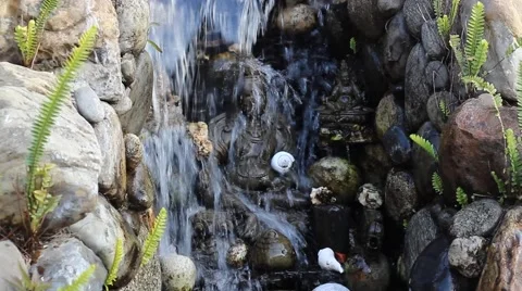 Statue of Buddha with eyes closed in a small waterfall Video stock 58990186
