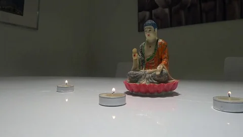 Statue of Buddha on white table with 3 candles 動画素材 71171194