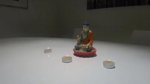 Statue of Buddha on white table with 3 candles 動画素材 71171627