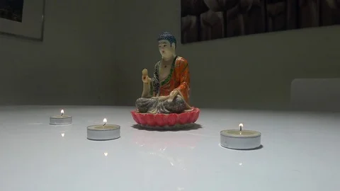 Statue of Buddha on white table with 3 candles 動画素材 71172696