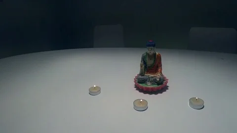Statue of Buddha on white table with 3 candles 動画素材 71173344