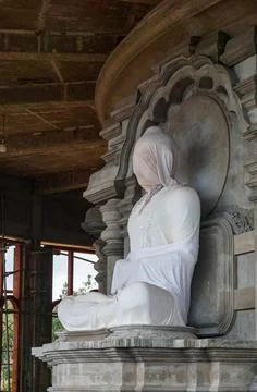 Statue of Buddha wrapped in white sheet in Buddhist temple under construction Foto stock