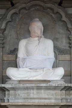 Statue of Buddha wrapped in white sheet in Buddhist temple under construction Foto stock