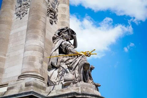 Statue in a column with a gold sword Stock Photos