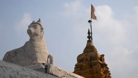 Statue of a cow in the background waving a flag on the roof of an Indian temple Video stock 137871466