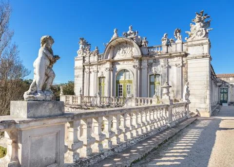 Statue of Cupid on a background of the facade of the old royal castle. Queluz Stock Photos