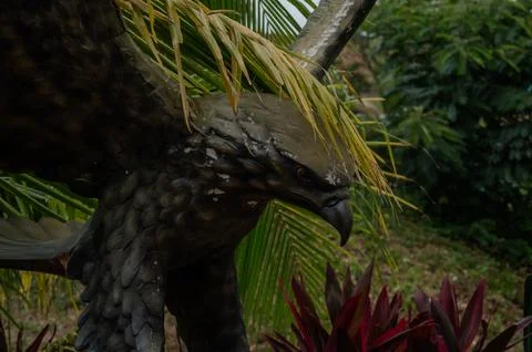 A statue of an eagle is perched on a tree branch Stock Photos