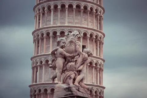 Statue in front of the tilted Pisa tower in Italy Stock Photos