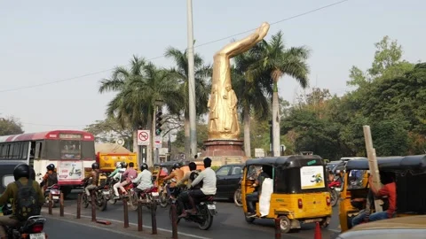 Statue of hand between the road and vehicles running around Vídeo Stock 147685396