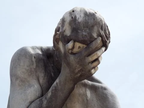 A statue holding its head in its hand Stock Photos