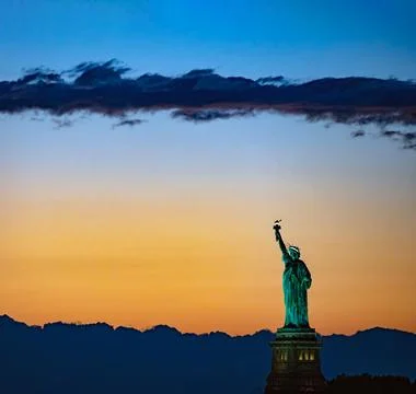 Statue of Liberty against dramatic orange twilight sky Foto stock