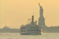 Statue of Liberty and sigtseeing boat at sunset Footage