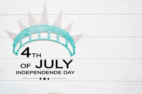 Statue of liberty crown on white wooden table with the text 4th of July Stock Photos