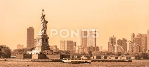 Statue of Liberty with Liberty State Park and Jersey City skyscrapers in Stock Photos