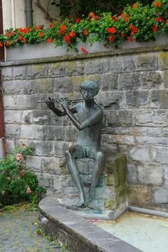 Statue of a man playing the pipe Stock Photos