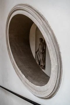 A statue of a man is reflected in a round window Stock Photos