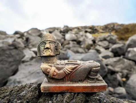 A statue of a man is sitting on a rock Fotos Stock