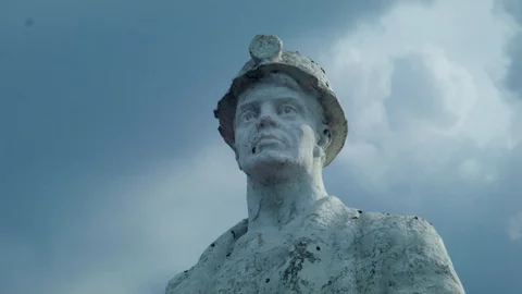 Statue of a miner on the background of running clouds. Stop motion Video stock 112392411