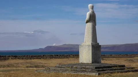A statue overlooks a distant cloud of smoke from an erutping volcano, Iceland. 動画素材 155750777